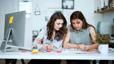 Genç kadın mimar ofis planı ile tartışıyor