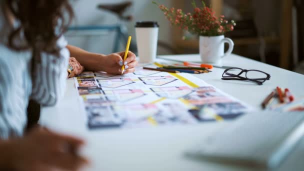 Primer plano de dos arquitectas discutiendo el plan juntas en el escritorio con planos . — Vídeo de stock