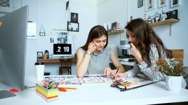 Jóvenes arquitectas discutiendo con el proyecto en la oficina — Vídeos de Stock