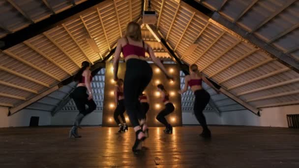 Des silhouettes de danseuses. Va danser. Performance de danse en gros plan d'un joli groupe féminin sur une scène sombre avec des lumières jaunes. danse d'équipe de femmes en talons hauts. 4k — Video