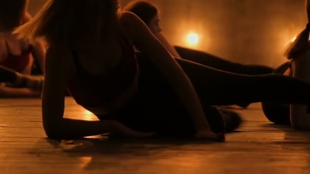 Silhouetten tanzender Mädchen. Go-Go-Tanz. Nahaufnahme Tanzperformance einer hübschen Frauengruppe auf einer dunklen Bühne mit gelben Lichtern. Mannschaftstanz der Frauen in High Heels — Stockvideo