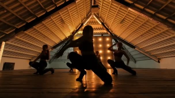 Silhouette di ballerine. go-go dance. Spettacolo di danza da primo piano di un gruppo femminile su un palco buio con luci gialle. danza di squadra di donne con i tacchi alti. 4k — Video Stock