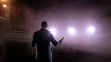 Şovmen. Genç erkek şovmen, sunum veya Sahne Alanı'nda aktör. İki taraf, Spot arka plan üzerinde duman için sırt, kollar.