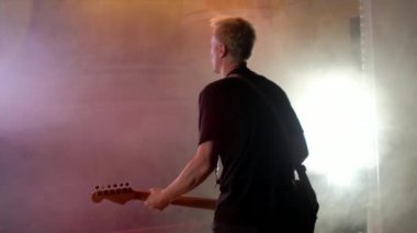 Gitarist sahne alanı'nda gerçekleştirir. Sahne ışık, duman.