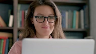 Öğrenci kitap ve Kütüphane içinde laptop ile çalışır