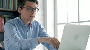 Öğrenci kitap ve Kütüphane içinde laptop ile çalışır