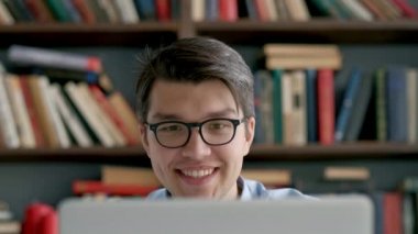 Sınav hazırlayan ve okul kütüphanesinde öğrenim dersleri alan öğrenci, dizüstü bilgisayarda araştırma yapıyor ve internette geziniyor