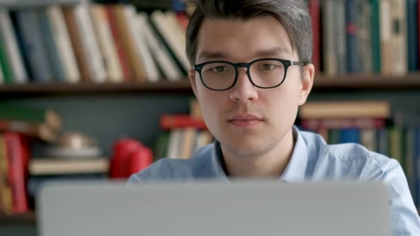 Estudiante preparando el examen y aprender lecciones en la biblioteca de la escuela, hacer investigación en el ordenador portátil y navegar por Internet — Vídeos de Stock