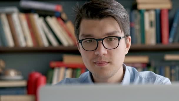 Estudiante preparando el examen y aprender lecciones en la biblioteca de la escuela, hacer investigación en el ordenador portátil y navegar por Internet — Vídeos de Stock