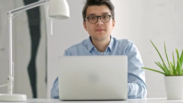 Manliga universitetsstudent tittar fundersamt på laptop skärm medan du gör läxor. Närbild av koncentrerad pojke försöker uppfylla svår uppgift medan du studerar — Stockvideo