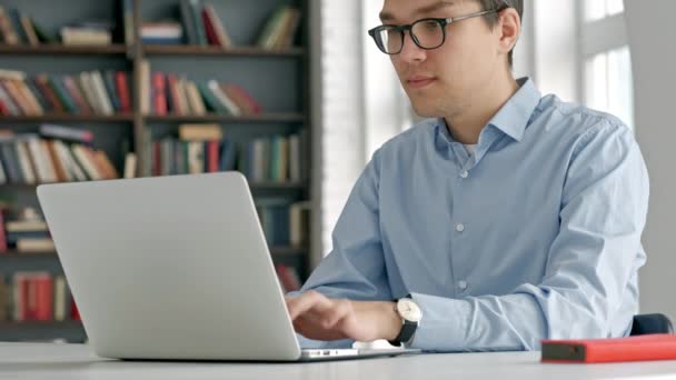 Mężczyzna studentka patrząc na ekran laptopa starannie podczas odrabiania lekcji. Zbliżenie z koncentratu chłopiec próbuje spełnić trudne zadanie podczas studiów — Wideo stockowe