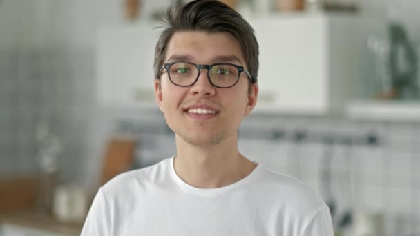 Primer plano retrato de atractivo joven hipster hombre mirando en serio a la cámara en el nuevo apartamento con gafas serie de personas reales — Vídeos de Stock