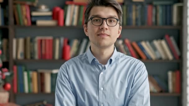 Portret jonge man student glimlachend boekenplank Bibliotheek Universiteit — Stockvideo