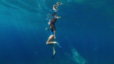 Şık ve atletik kız dalgıç okyanusun derinliklerinde yalnız. Yüzücü esmer mavi sualtı arka plan üzerinde derin okyanusta dalış