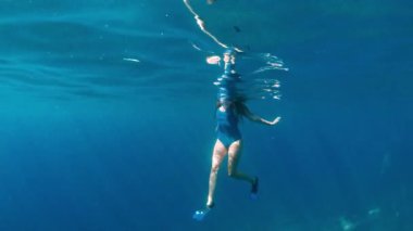 Şık ve atletik kız dalgıç okyanusun derinliklerinde yalnız. Yüzücü esmer mavi sualtı arka plan üzerinde derin okyanusta dalış.