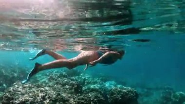 Tropikal deniz mercan kayalıkları üzerinde şnorkel genç bayan. Snorkeling maske temiz su ile kadın