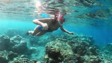Tropikal deniz mercan kayalıkları üzerinde şnorkel genç bayan. Snorkeling maske temiz su ile kadın