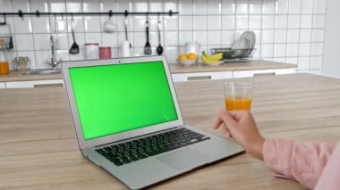 Telefonunuzun ve daire, çekici Bayan içinde laptop ile masada oturan genç mutlu kadın ev mutfak masasında modern cihazlar ile iyi vakit geçiriyor. Konsept: sosyal medya, yaşam tarzı, modern