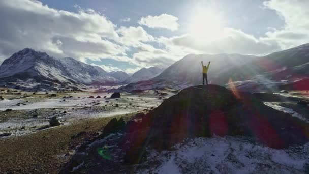 Scalatore di montagna maschio alzando le mani con ghiaccio sulla cima della vetta innevata — Video Stock
