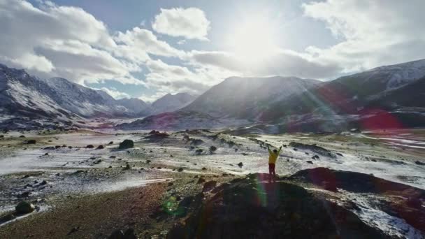 雪に覆われた山範囲空中飛行壮大な勝利の人生気持ち宗教概念の夕日トップ両腕成功ポーズに達する若いハイカー — ストック動画