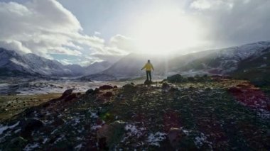 Bir adam bir uçurumun üstünde duruyor ve güzel bir manzaraya sahiptir. Macera ve seyahat kavramı.