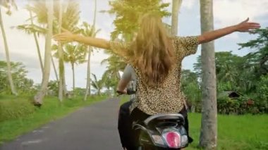 Mutlu çift motosiklet ile tropikal yolda günbatımı anda açma. Genç çift motosiklet sürme açık bir kadeh. Bir motosiklet üzerinde kız kırsal yolda kişini.