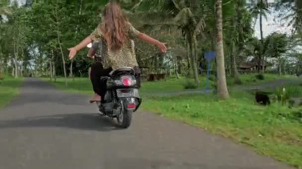 Couple riding their scooter through forest. life style idea concept. Young beautiful couple rides the jungle on a scooter, travel, freedom, happiness, vacation, honeymoon concept — Stock Video