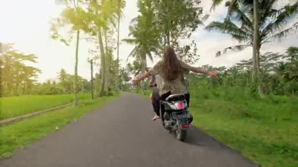 Paar rijden hun scooter door bos. Privaatleven idee concept. Jonge mooie paar rijdt de jungle op een scooter, reizen, vrijheid, geluk, vakantie, huwelijksreis concept — Stockvideo