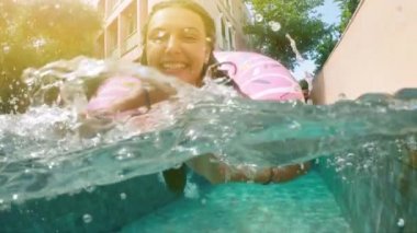 Kadın mavi bikini şişme pembe çörek float havuzu içinde güneşli yaz günü yatan güneş gözlüklü. Kameraya bak. Kadın bikini yüzme havuzunda rahatlatıcı tatil karpuz Kauçuk halka