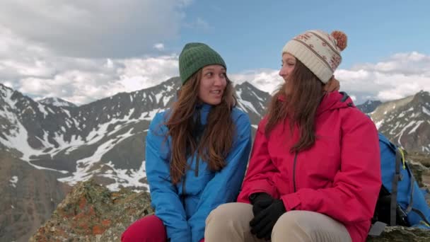 Dos excursionistas relajándose en la cima de la colina y disfrutando del amanecer sobre el valle — Vídeos de Stock