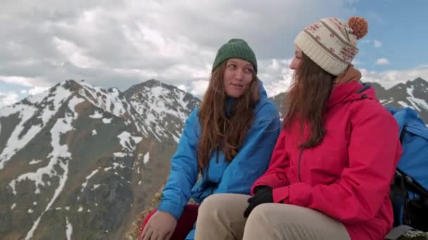 Dos excursionistas relajándose en la cima de la colina y disfrutando del amanecer sobre el valle — Vídeo de stock