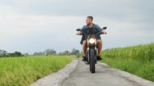 田舎道でヘリに乗っている若い男。美しい山道。バイクで旅行する. — ストック動画