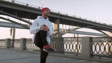 streç adam eğitim kentsel. Genç esnek erkek, şehir çevresinde, yavaş çekimde derinlere uzanıyor