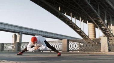 Temiz havada egzersiz yapmak. Kendinden emin genç adam açık havada dururken koşmadan önce vücudunu germe