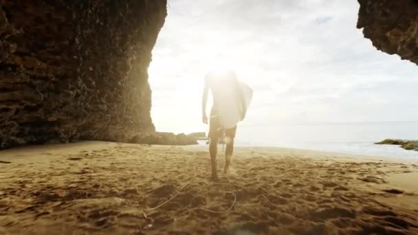 Desfrute da sua vida Homem caminhando com prancha de surf em direção ao Oceano Pacífico para pegar ondas Estilo de vida Bali Vista deslumbrante do pôr do sol — Vídeo de Stock