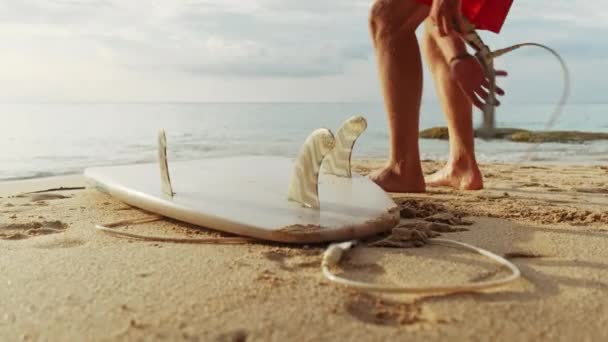 Egy férfi a kezében, a tenger partján áll egy surf. — Stock videók