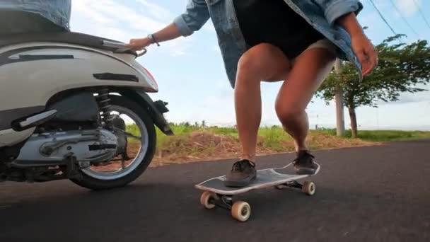 Groep vrienden schaatsen en motorrijden. Vrolijke tieners hebben plezier buitenshuis. Twee vrouwen rijden op een zonnige dag. Gelukkig jong stel plezier met skateboard op de weg. — Stockvideo