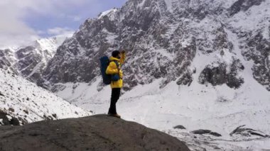 Dağın tepesindeki turist. Spor ve aktif yaşam. Sırt çantası ile Yürüyüşçü bir dağın tepesinde duran ve gün doğumu zevk. Genç Hiker Gün Batımında Başarılı Dağ Zirvesinde