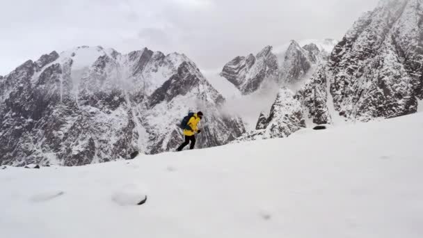 Bergsteiger männliche gelbe Jacke, die bei Sonnenuntergang den Berg hinaufgeht und den Gipfel erreicht, fliegen über Drohnenaufnahmen aus der Luft. Siegerkonzept. — Stockvideo