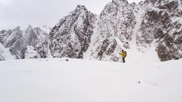 Bergsteiger männliche gelbe Jacke, die bei Sonnenuntergang den Berg hinaufgeht und den Gipfel erreicht, fliegen über Drohnenaufnahmen aus der Luft. Siegerkonzept. — Stockvideo