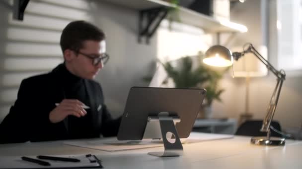 Architecte travaillant au bureau. Dessine avec un stylo ou des outils sur tablette. Portrait d'affaires d'un bel homme d'affaires portant des lunettes de vue assis sur le lieu de travail. Un homme d'affaires confiant est devenu un succès. — Video