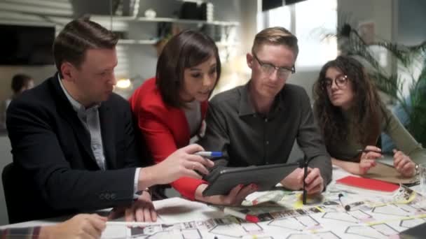 Im Kreativbüro stehen produktive Mitarbeiter am Tisch und treffen sich. Geschäftsleute sprechen über Strategie mit Tablet Teamarbeit und soziale Konzepte. — Stockvideo