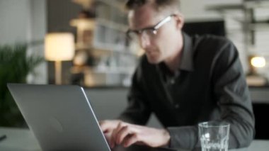İnternette Laptop kullanan, internette çalışan, bilgisayarlı internette bilgisayar sörfü yapan, bilgisayarlı internete bakan, bilgisayarlı internetteki işine bakan, gülümseyen genç adam.