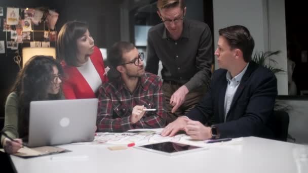 Team Of Architects Working On Project Paper Blueprint. Groupe de gens d'affaires modernes dans l'usure occasionnelle Discuter des conceptions architecturales tout en étant assis dans le bureau créatif.