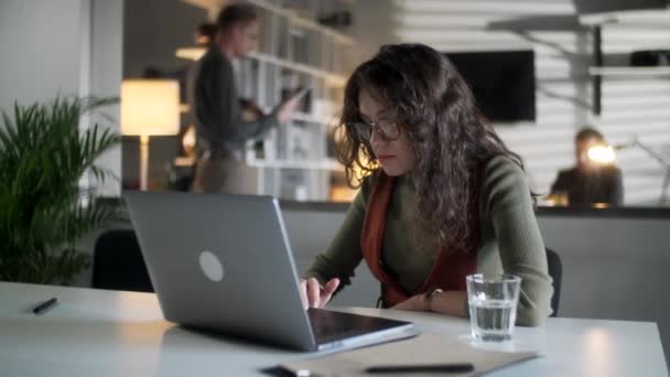 Молода ділова жінка професійний підприємець використовуючи ноутбук комп'ютерний зошит на робочому місці Введення електронної пошти Примітки сидячи на столі Робота онлайн робота в сучасному корпоративному офісі — стокове відео