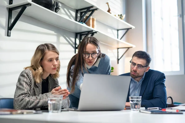 Colegas y clientes que hablan estrategia con el ordenador portátil y la tableta. En Creative Office Productive Coworkers De pie en la mesa para la reunión de la empresa. Trabajo en equipo y conceptos sociales — Foto de Stock