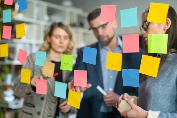 Creative Business Team Brainstorming Ideas Working Together Near Glass Wall with Sticky Notes. Коллеги одобряют. Концепция успеха бизнеса — стоковое фото