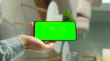 Uzayı Kopyalamak için Yeşil Ekranlı Telefondaki Adamın POV Görünümü. Chromakey İşaretlemesiz Mock Up. 20 'li yaşlarda Kanepe Yakından Video Haberleri seyrediyor. Ekran Merkezine Tıklanacak Tıklama