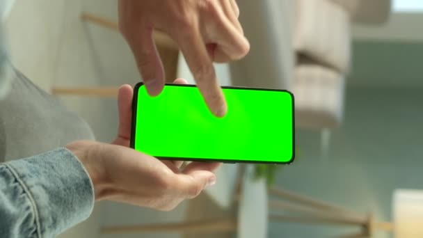 Vista POV del hombre en el teléfono con pantalla verde para copiar el espacio. Chromakey se burla. Veinte años Boy viendo el vídeo de noticias en el sofá de cerca. Toque para hacer clic en el centro de la pantalla con orientación vertical de la pantalla 9: 16 — Vídeo de stock