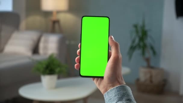 Achteraanzicht van de vrouw aan de telefoon met groen scherm voor kopieerruimte. Chromakey Mock Up zonder sporen achter te laten. Twintiger jaren Lady Kijken Video Nieuws op Couch Close-up. Opvegen. — Stockvideo